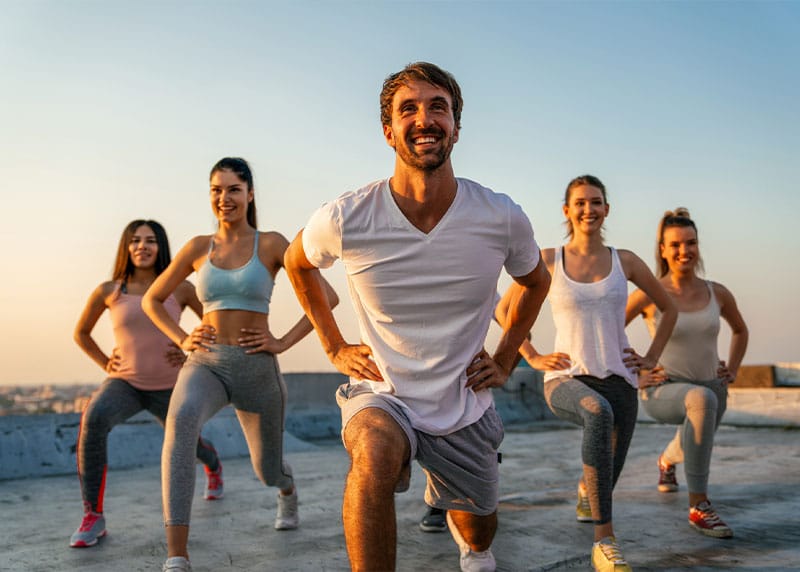 a group of people doing stretches on the beach after getting prescription weight loss in Fort Myers