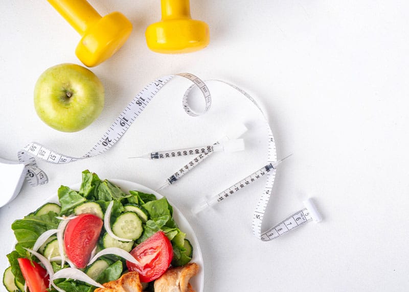 a salad next to some vegetables next to a tape measurer next to Tirzepatide weight loss in Fort Myers